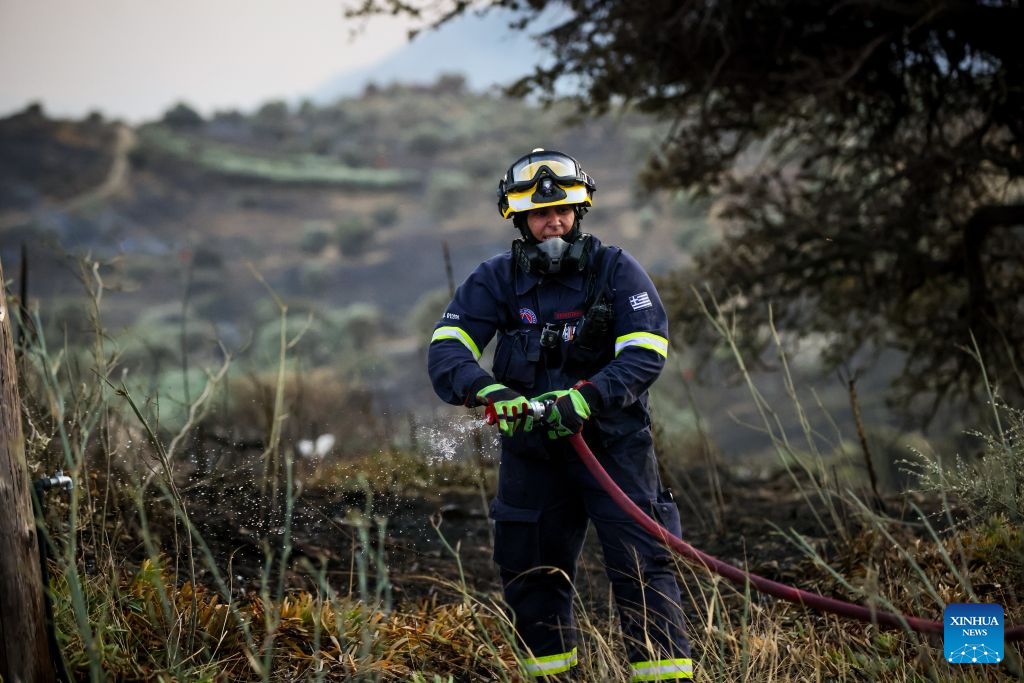 A firefighter takes part in firefighting operations in Rethymno on the island of Crete, Greece, July 29, 2026. Two firefighters lost their lives while battling a fast-moving wildfire in Rethymno on the Greek island of Crete on Wednesday, as gale-force winds fueled the blaze across a front stretching more than 15 kilometers. (Photo by Rapanis Spiros/Xinhua)