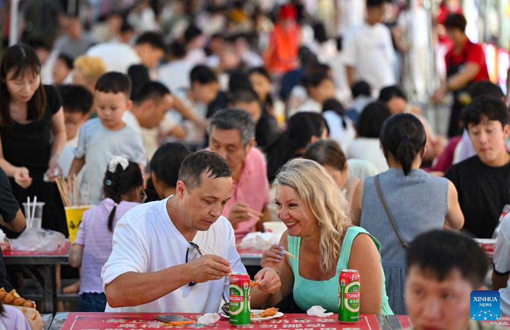 Tourists enjoy food at a night market in Haikou, south China's Hainan Province, July 17, 2026. Hainan is seeing a surge in visitors during the summer holiday season. (Xinhua/Guo Cheng)
