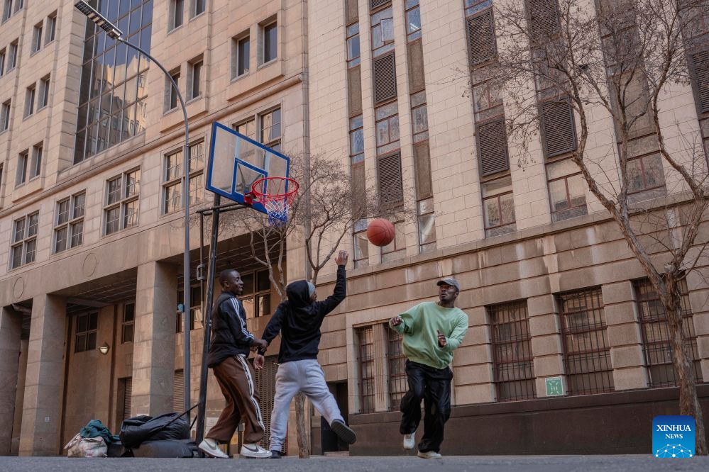 People play basketball on a street during a car-free event in Johannesburg, South Africa, Aug. 9, 2026. During the event, some streets in Johannesburg were turned into car-free zones from 10 a.m. to 5 p.m., with motor vehicles banned. (Photo by Ihsaan Haffejee/Xinhua)