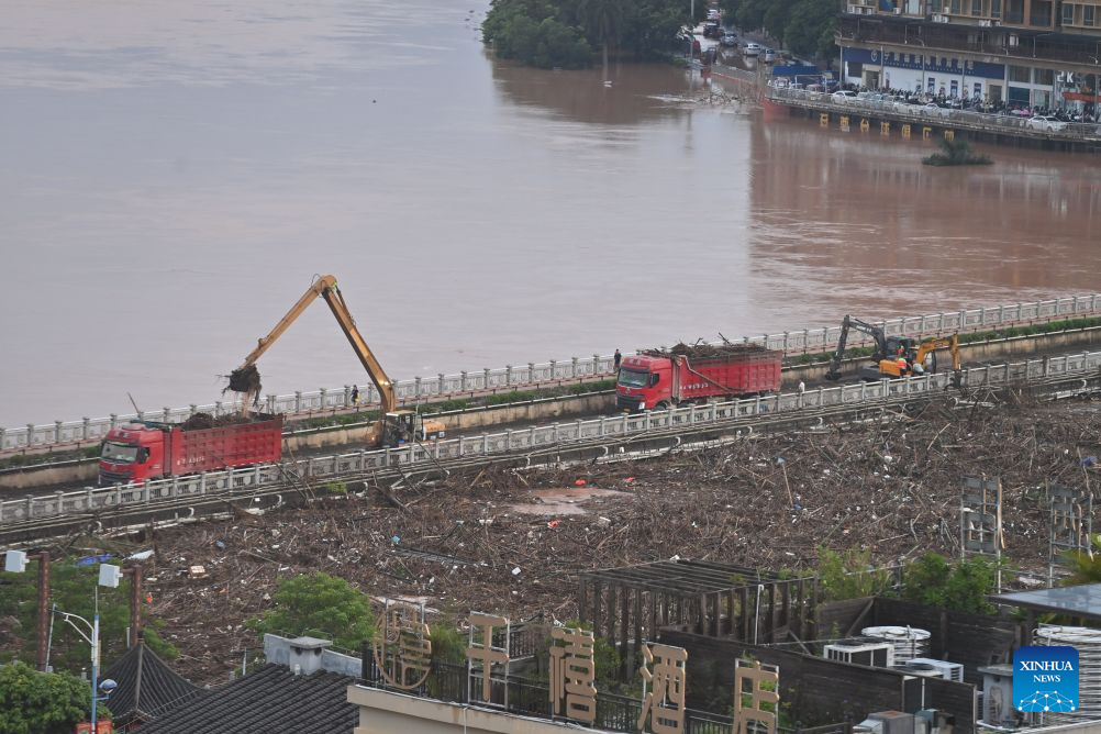 Rescue vehicles are deployed on a bridge to help remove flood debris in the Mingjiang River in Ningming County, south China's Guangxi Zhuang Autonomous Region, Aug. 24, 2026. Rescue forces have been deployed in Ningming County where typhoon-triggered heavy rainfall caused flood in the Mingjiang River and its tributaries on Sunday. (Xinhua/Zhou Hua)