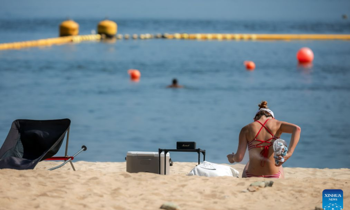 People relax on a beach in Hong Kong, south China, Aug. 9, 2026. Hong Kong's temperature had reached 36.9 degrees Celsius by 3:30 p.m. on Sunday, the highest since the city started keeping meteorological records in 1884, according to the Hong Kong Observatory. (Xinhua/Lui Sui Wai)