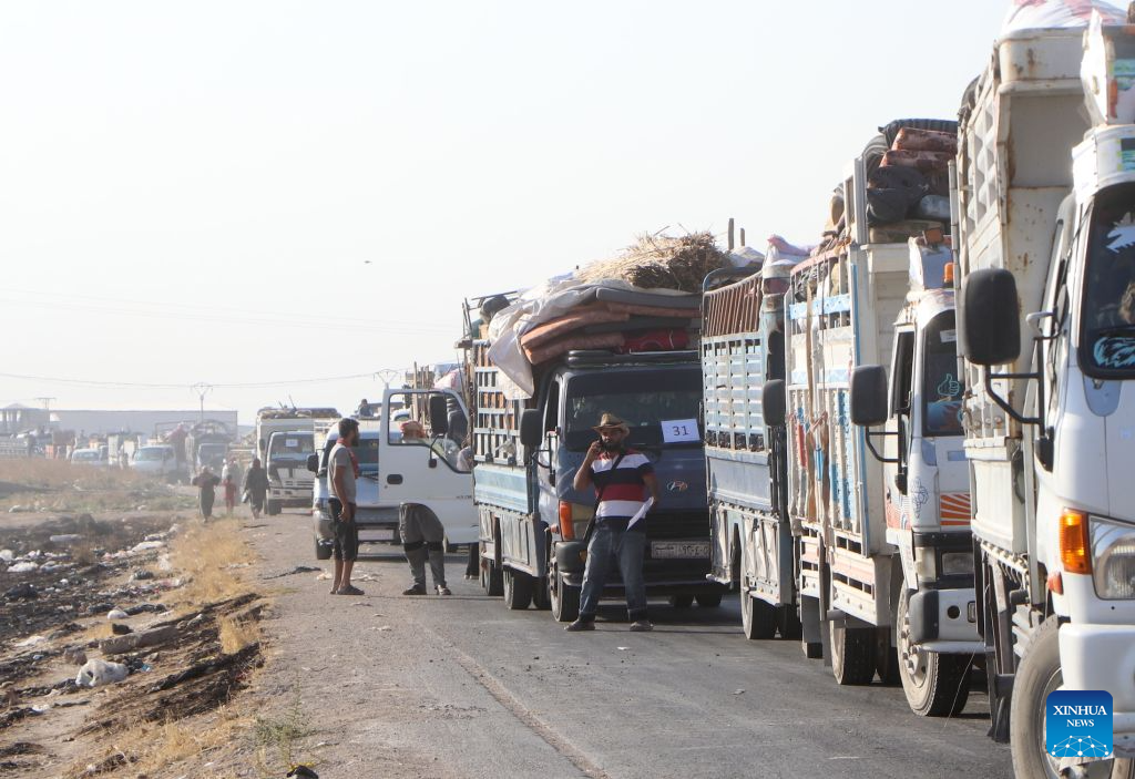 Trucks loaded with the belongings of displaced Syrian families line up as a convoy prepares to head toward the city of Ras al-Ain and its surrounding villages in Hasakah province, northeastern Syria, Aug. 10, 2026. More than 400 Syrian families returned to the city of Ras al-Ain in northeastern Hasakah province and its surrounding villages on Monday, marking the first organized convoy of displaced residents heading home in that area after nearly seven years of displacement. (Str/Xinhua)