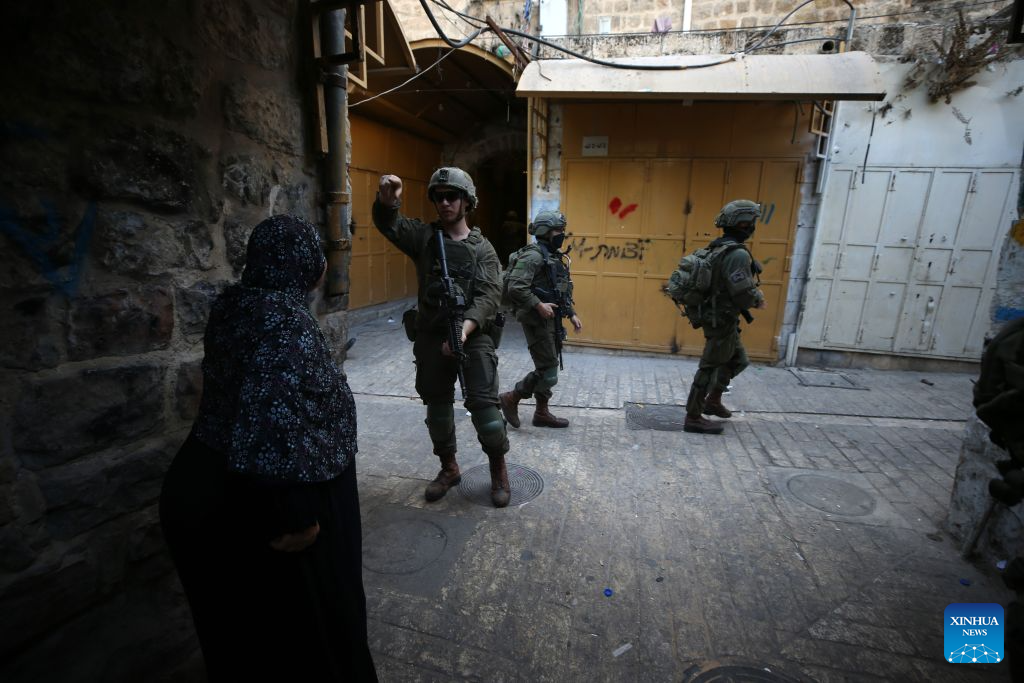 Members of Israeli forces secure the streets for Israeli settlers during a military raid in the Old City of Hebron, in the West Bank, Aug. 29, 2026. (Photo by Mamoun Wazwaz/Xinhua)