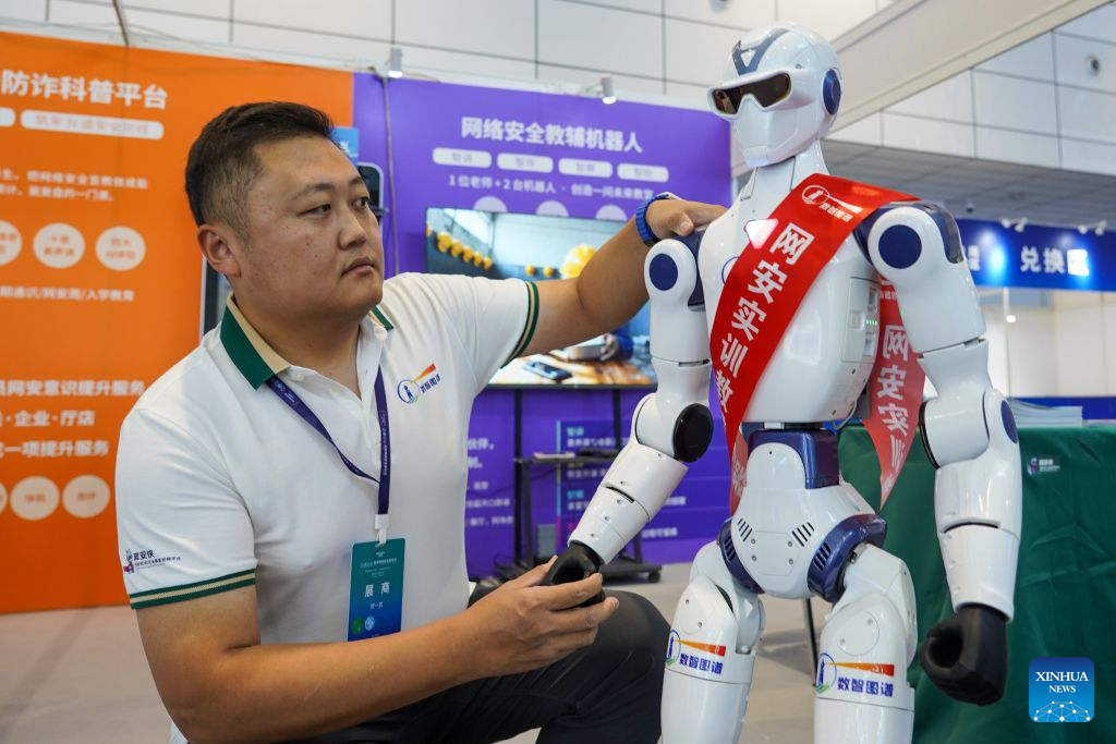An attendee adjusts a robot at the experience zone of cybersecurity technology applications at the 2026 China Cybersecurity Week in Jinan, east China's Shandong Province, Sept. 14, 2026. The 2026 China Cybersecurity Week held its opening ceremony here on Monday. The event will be held across China from Sept. 14 to 20. (Xinhua/Zhu Zheng)