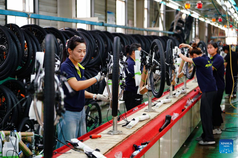 Workers assemble bicycles in a workshop of a bicycle company in Pingxiang County, Xingtai City, north China's Hebei Province, July 22, 2026. Xingtai City is a nationally renowned bicycle manufacturing base, with its products sold worldwide. In recent years, Xingtai has pushed forward the upgrading of the bicycle industry, continuously improved cycling infrastructure, and hosted a wide range of professional cycling races and mass public riding events. By integrating manufacturing and cycling events, the city has fueled accelerated growth of the local bicycle sector. (Photo by Feng Yichao/Xinhua)