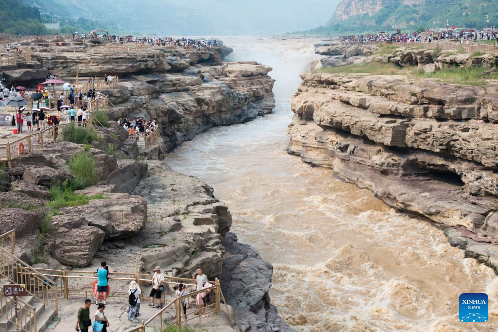 Tourists visit the Yellow River's Hukou Waterfall in northwest China's Shaanxi Province, Aug. 10, 2026. (Xinhua/Shao Rui)
