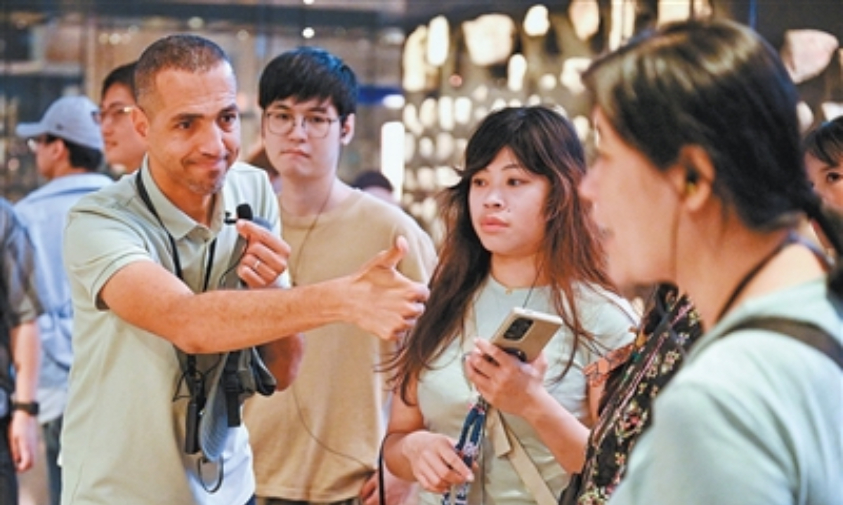 Egyptian tour guide Abbas (left) speaks to visitors at the Grand Egyptian Museum in July 2026. Photo: Xin Mengchen / Xinhua