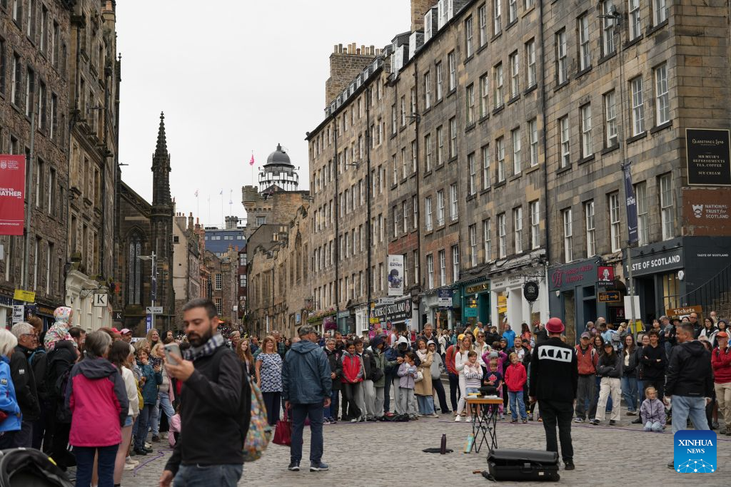 This photo taken on Aug. 9, 2026 shows people watching a street show during the 2026 Edinburgh festival season in Edinburgh, Britain. A series of cultural events, including the Edinburgh International Festival, the Edinburgh Festival Fringe, and the Royal Edinburgh Military Tattoo, kicked off in Edinburgh on Aug. 7, attracting artists and audiences from around the world. (Xinhua/Zhao Jiasong)