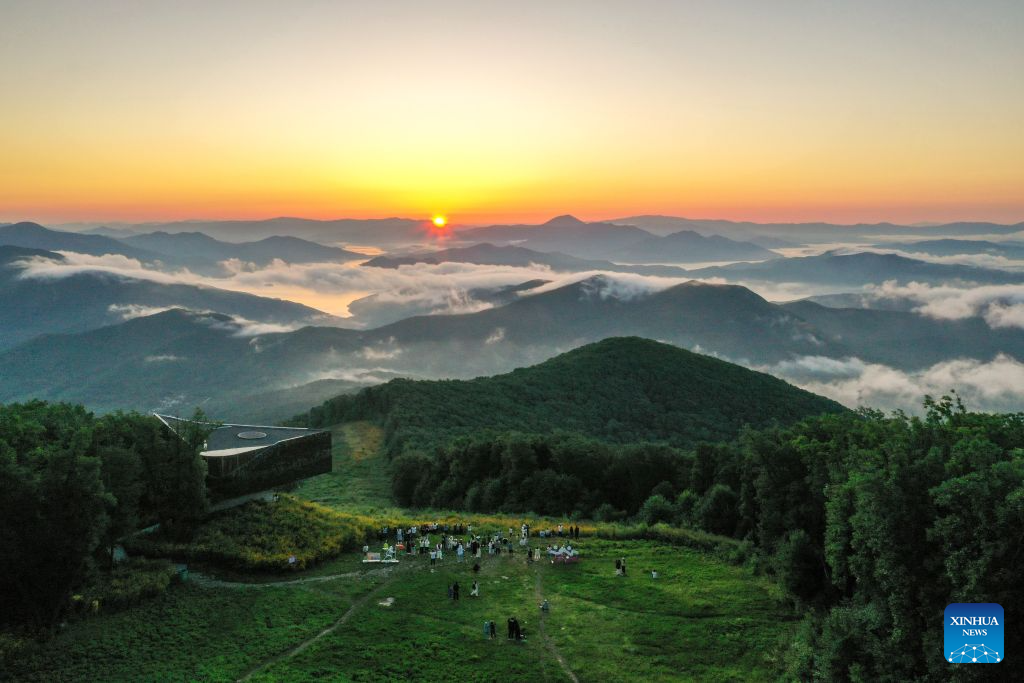 A drone photo taken on Aug. 12, 2026 shows tourists watching sunrise at the Lake Songhua Resort in Jilin City, northeast China's Jilin Province. The Lake Songhua Resort, located in Jilin City, is a national-level ski tourism resort. In recent years, relying on its mountain resources, the resort has extended operation in other seasons except for winter, attracting tourists with natural scenery and mountain sports.

Since April 25 this year, the resort has received a total of 200,000 visitors, a year-on-year growth of 20 percent. From popular destination in winter to year-round operation, the tourism potential of the resort is being fully tapped, promoting the high-quality development of the local cultural and tourism industry. (Xinhua/Zhang Nan)