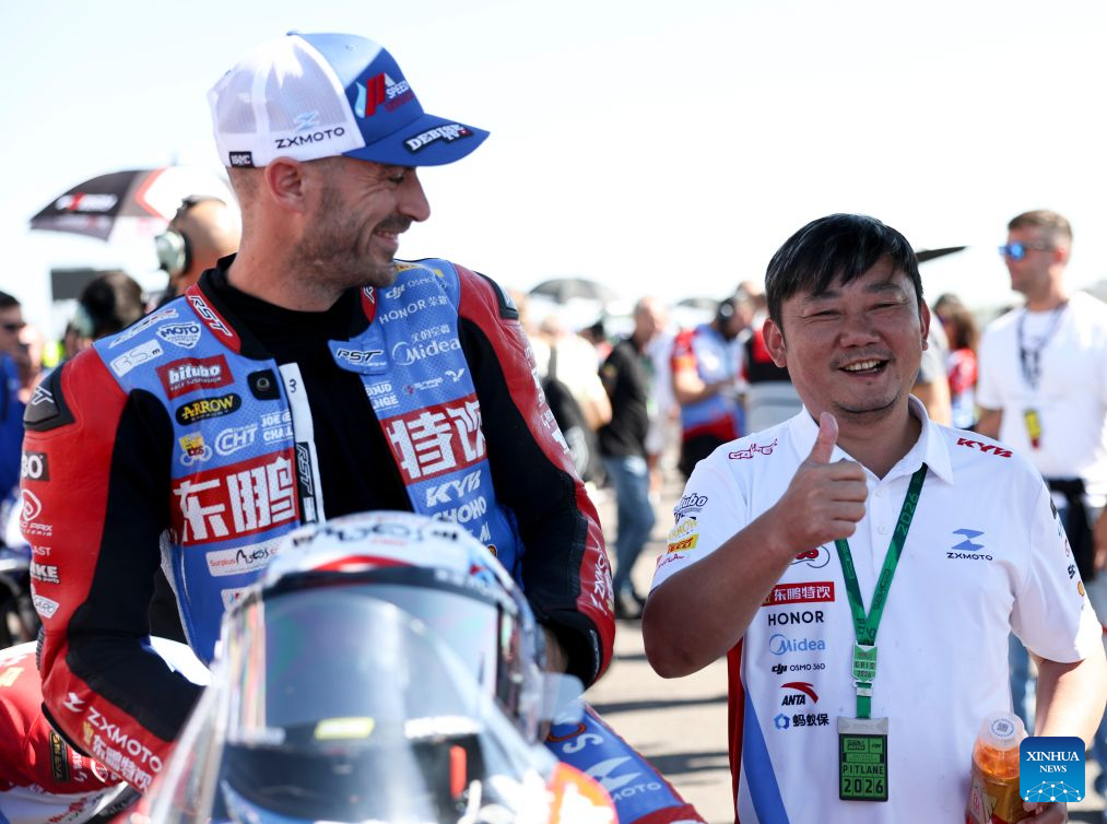Zhang Xue (R), founder of ZXMOTO reacts with Valentin Debise of EASTROC ZXMOTO Evan Bros Factory before during the Race 2 of WorldSSP at the FIM Supersport World Championship Italian Round Cremona Circuit, Italy, Sept. 27, 2026. (Xinhua/Li Jing)