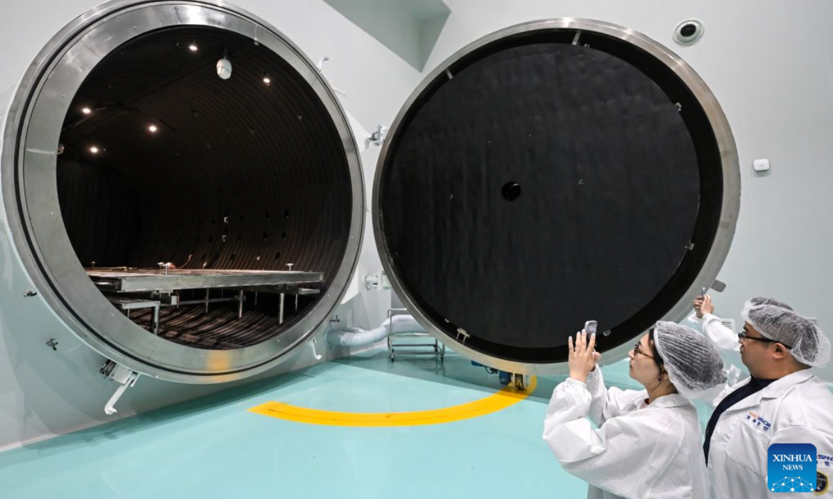 Journalists take photos of a thermal vacuum simulator at Guoyu Starry Sky Technology Co., Ltd. in the high-tech zone of Wuxi, east China's Jiangsu Province, July 20, 2026. Guoyu Starry Sky Technology Co., Ltd. specializes in the design and manufacturing of satellites. Its intelligent production line for commercial satellites can produce more than 150 units annually, each weighing between 200 kg and 500 kg. (Xinhua/Chen Yehua)