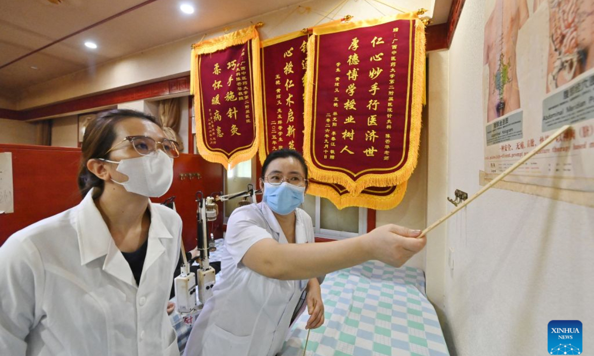 Dr. Chen Manghua explains acupuncture know-how to Thai Thi Hai Yen (L) at the Second Affiliated Hospital of Guangxi University of Chinese Medicine in Nanning, south China's Guangxi Zhuang Autonomous Region, Sept. 17, 2026. (Xinhua/Lu Boan)