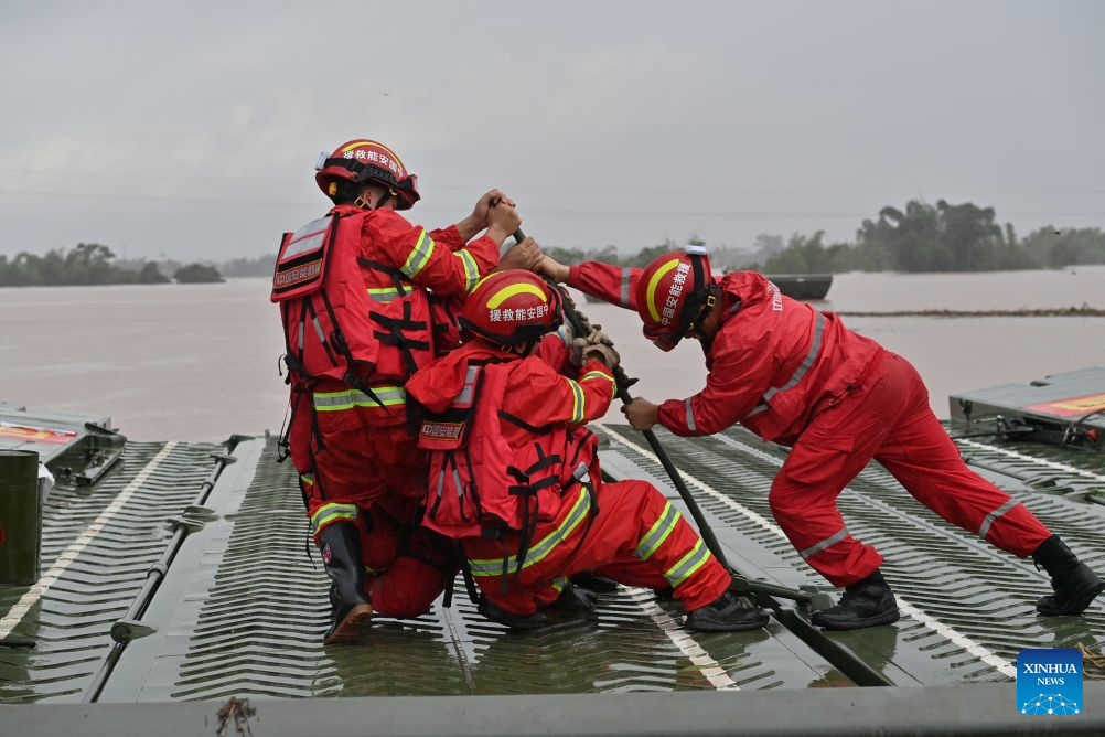 Rescuers assemble a powered pontoon bridge in Beijiang Township, Ningming County, south China's Guangxi Zhuang Autonomous Region, Aug. 24, 2026. Rescue forces have been deployed in Ningming County where typhoon-triggered heavy rainfall caused flood. A powered pontoon bridge was deployed for emergency rescue operations on Monday. (Xinhua/Zhou Hua)