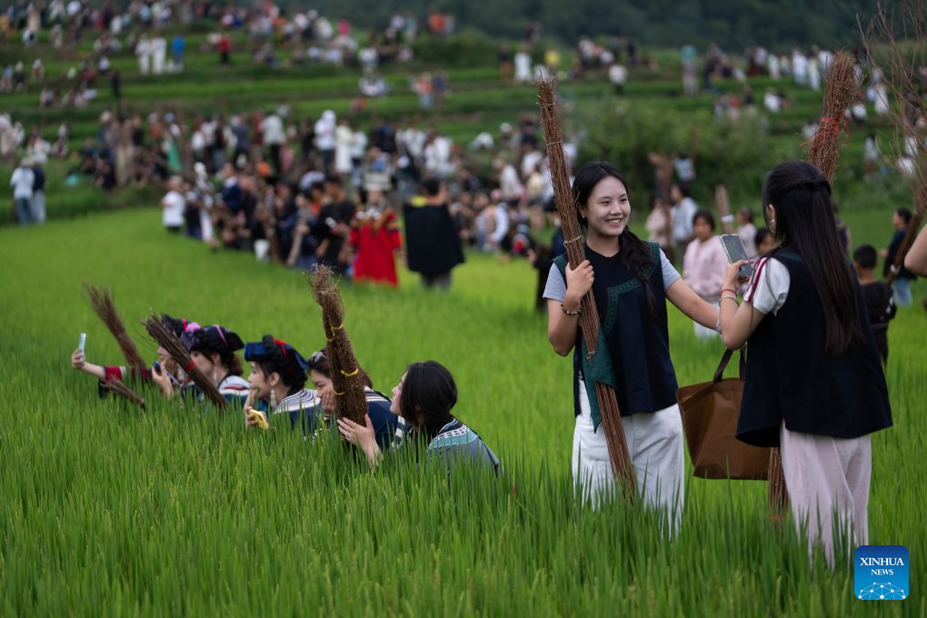 Visitors from Chengdu wait for the nightfall to light up the torches at a terraced field in Yangpo Village, Yuexi County of southwest China's Sichuan Province, Aug. 4, 2026.(Xinhua/Jiang Hongjing)