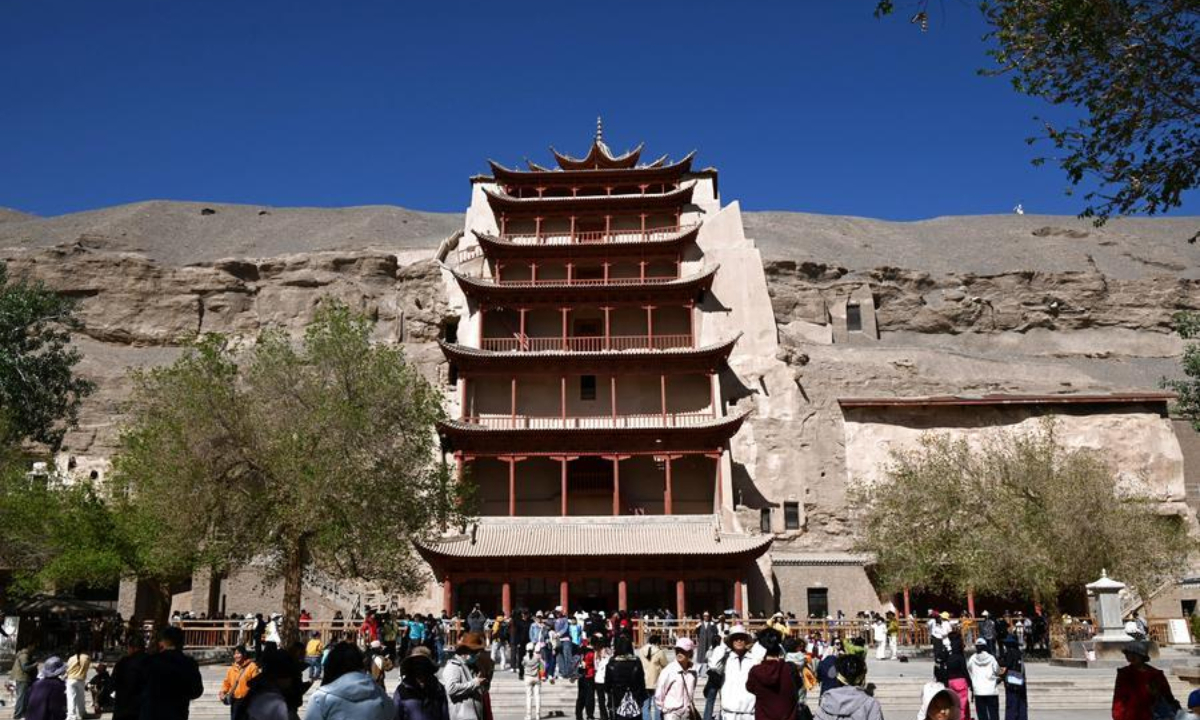 Tourists visit the Mogao Grottoes in Dunhuang City, northwest China's Gansu Province, on May 2, 2026. (Photo by Zhang Xiaoliang/Xinhua)