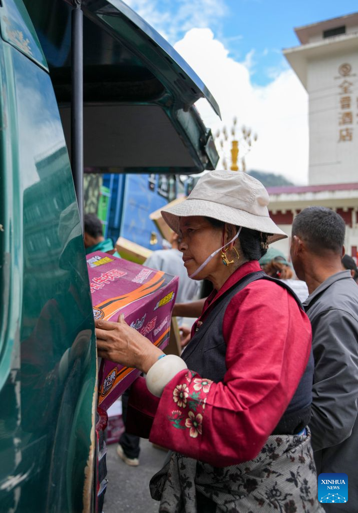 People unload instant noodles from a vehicle in Gyirong Town of Gyirong County, Xigaze City, southwest China's Xizang Autonomous Region, Aug. 27, 2026. Six vehicles loaded with relief supplies, including instant noodles, rice, flour, mineral water and other daily necessities, arrived in Gyirong Town on Thursday afternoon. (Xinhua/Jigme Dorje)