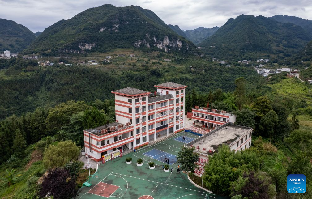 An aerial drone photo taken on Aug. 30, 2026 shows the Guanzhai primary school on the top of the Nizhu River Grand Canyon in Puli Township, Xuanwei City, southwest China's Yunnan Province. Nizhuhe Village is located at the bottom of the Nizhu River Grand Canyon in southwest China's Yunnan Province. What separates Nizhuhe Village and the Guanzhai primary school on the mountain top is a vertical drop of over 500 meters. Students living at the canyon bottom used to take nearly half a day to travel from home to school.
In 2022, significant changes in the means of local commuting took place upon the completion and opening of the Nizhu River Grand Canyon scenic area, which came with a 268-meter-high cliff elevator and a cable car system that were available to local villagers, including students, free of charge.
Today, the combination of sightseeing shuttle vehicles, elevators and cable cars has shortened students' journey to school to about 30 minutes. A dedicated passage has also been set up for them, with police officers and dedicated staff members deployed along the commuting route. (Xinhua/Chen Xinbo)