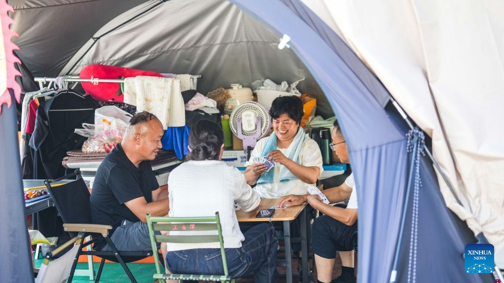 Campers play cards at a RV (recreational vehicles) camping base in Bijie City, southwest China's Guizhou Province, Aug. 11, 2026. In recent years, Bijie City has leveraged its scenic natural environment and pleasant mountain climate to promote the development of RV camping bases and boost summer tourism, drawing RV travelers from across China. (Xinhua/Tao Liang)