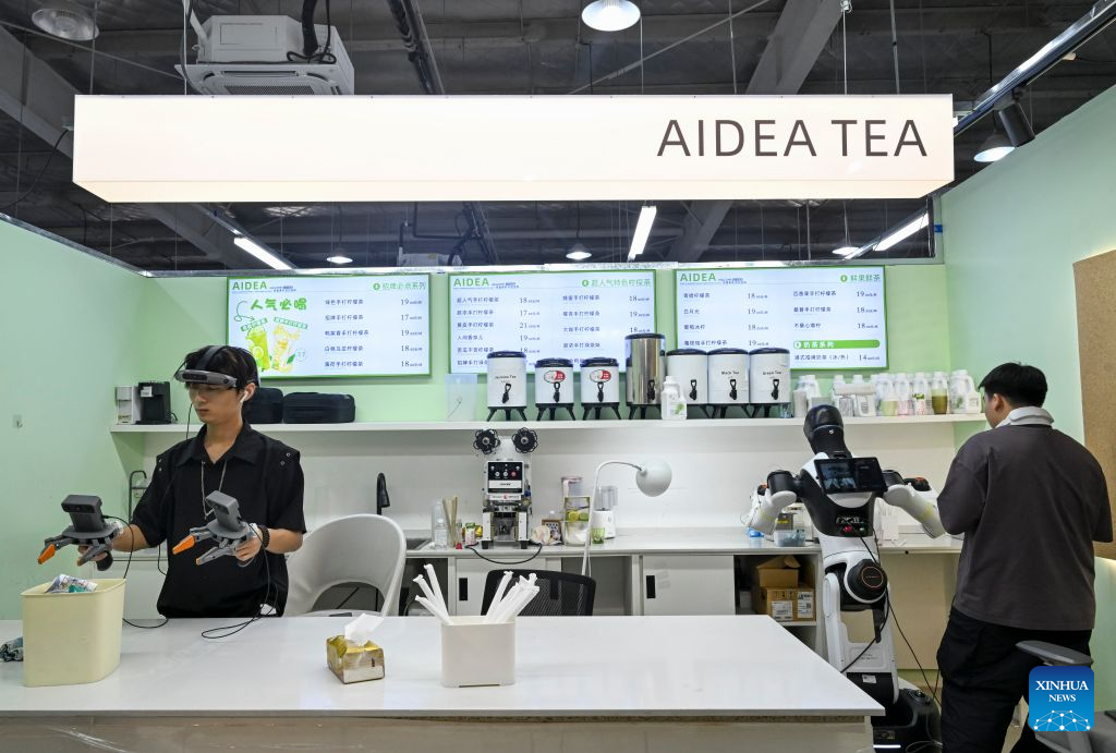 Staff members train a robot to work in a retail scenario at Maniformer, a physical AI data service platform, in Shanghai, east China, Aug. 5, 2026. In Shanghai's tech companies like AGIBOT and Maniformer, embodied intelligence robots are trained in household, retail, sorting, production and other real-world scenarios, to advance their AI capabilities for real-life use. (Xinhua/Chen Haoming)