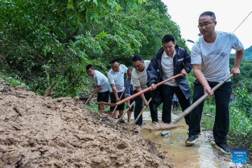 People clear a road blocked by a mudslide in Fanjiaping Village of Yuhe Town in Longnan, northwest China's Gansu Province, on Aug. 1, 2026. Longnan in northwest China's Gansu Province has activated Level II emergency response for flood control due to widespread heavy rainfall since Wednesday. Authorities at different levels have carried out inspections and assessments for potential hazards and repairs of damaged infrastructure, so as to safeguard people's lives and property. (Xinhua/Lang Bingbing)