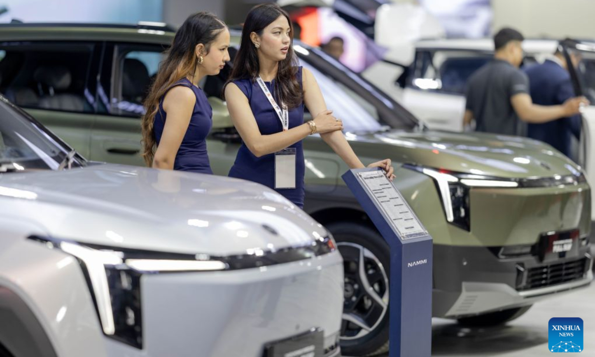 Vehicles are pictured with promotional models at the booth of Chinese automaker Dongfeng during the 18th NADA Auto Show in Kathmandu, Nepal, Aug. 25, 2026. Nepal's 18th NADA Auto Show kicked off here on Tuesday, bringing together more than 50 vehicle brands. Organized by the NADA Automobiles Association of Nepal, the five-day exhibition features around 200 stalls displaying four-wheelers, two-wheelers, auto parts and related services. (Photo by Sulav Shrestha/Xinhua)