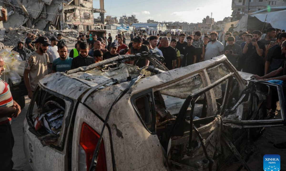 Palestinians gather around a burned vehicle following an Israeli drone strike targeting a civilian vehicle, in the Tel al-Hawa area west of Gaza City, Oct. 8, 2026. Two Palestinians were killed and several others injured Thursday in an Israeli strike targeting a vehicle west of Gaza City, according to medical and local sources. (Photo by Rizek Abdeljawad/Xinhua)