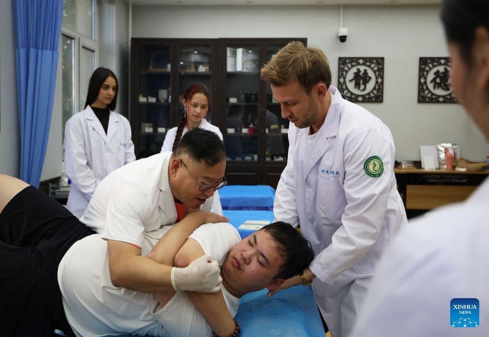 Professor Dong Baoqiang (L, front) demonstrates bone-setting treatment for foreign students at Liaoning University of Traditional Chinese Medicine in Shenyang, northeast China's Liaoning Province, Sept. 3, 2026. Liaoning University of Traditional Chinese Medicine attaches great importance to international exchange and cooperation, having established partnerships with universities, medical institutions, and academic organizations from 35 countries and regions.

With the arrival of the new semester, a group of international students from the United States, Russia, Australia, Pakistan, El Salvador, Brazil, Vietnam, Thailand and other countries have enrolled at Liaoning University of Traditional Chinese Medicine to learn Traditional Chinese Medicine (TCM) physiotherapies such as cupping, acupuncture, moxibustion, and bone-setting treatments. (Xinhua/Han He)