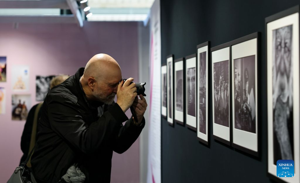 A visitor takes photos during a photography exhibition at the Salon Photo & Video in Paris, France, Oct. 8, 2026. The Salon Photo & Video opened in Paris on Thursday, featuring equipment displays, photography exhibitions, talks and hands-on activities. (Xinhua/Wu Huiwo)