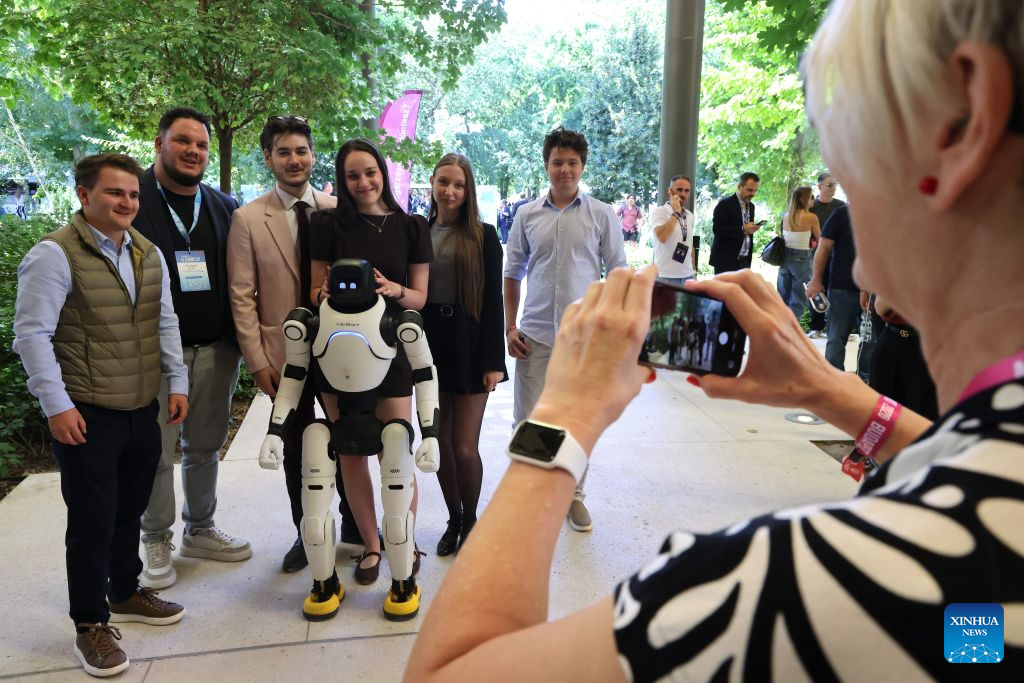 People pose for photo with a humanoid robot at the AI Summit Budapest 2026 in Budapest, Hungary on Sept. 7, 2026. (Photo by Attila Volgyi/Xinhua)