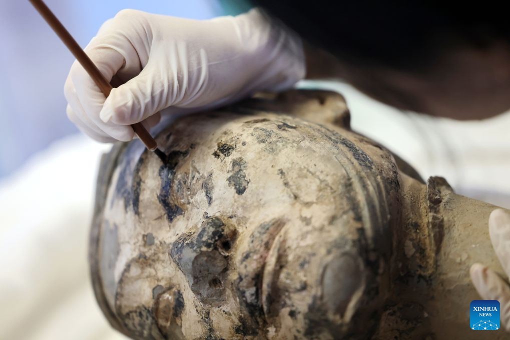 A restoration specialist conserves the paint on the head of a terracotta warrior at the on-site conservation lab of the Pit No.1 of the Emperor Qinshihuang's Mausoleum Site Museum in Xi'an, northwest China's Shaanxi Province, Sept. 3, 2026. (Xinhua/Li Yibo)