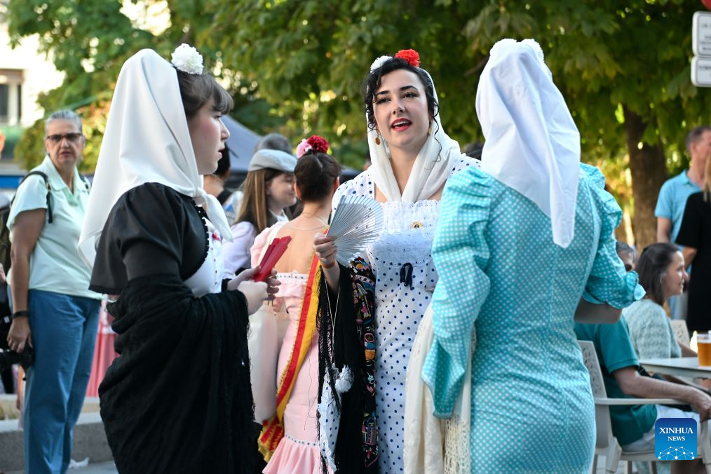 People dressed in traditional attire are seen during the San Cayetano Festival in Madrid, Spain, Aug. 4, 2026. (Photo by Gustavo Valiente/Xinhua)
