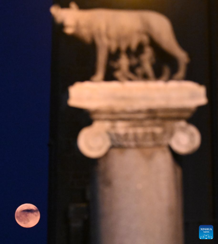 This photo taken on July 29, 2026 shows a full moon and the She-Wolf with Romulus and Remus statue in Rome, Italy. (Photo by Alberto Lingria/Xinhua)