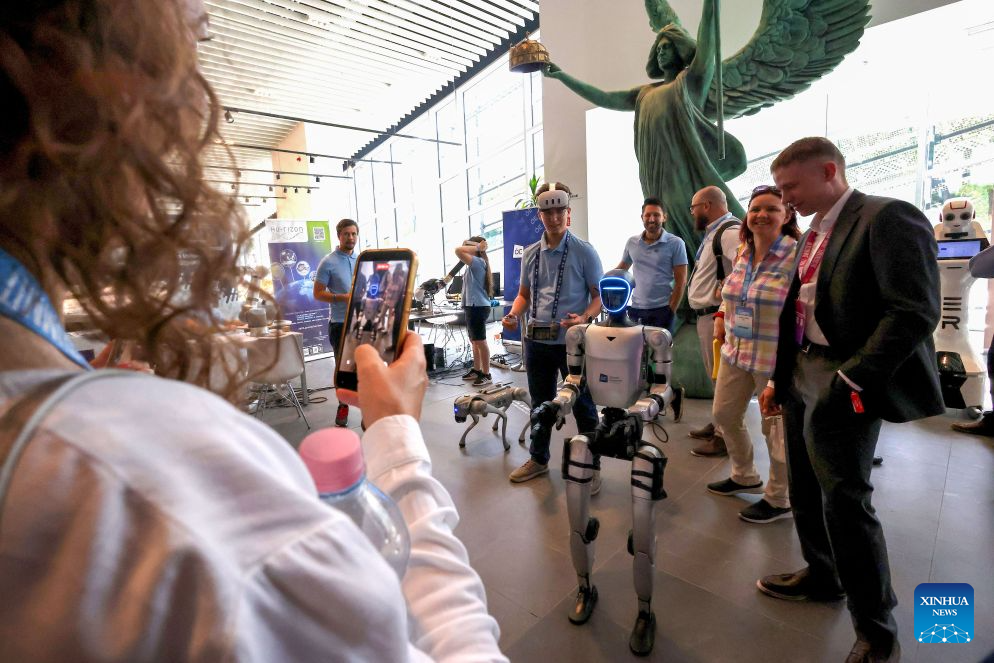 People look at a humanoid robot at the AI Summit Budapest 2026 in Budapest, Hungary on Sept. 7, 2026. (Photo by Attila Volgyi/Xinhua)
