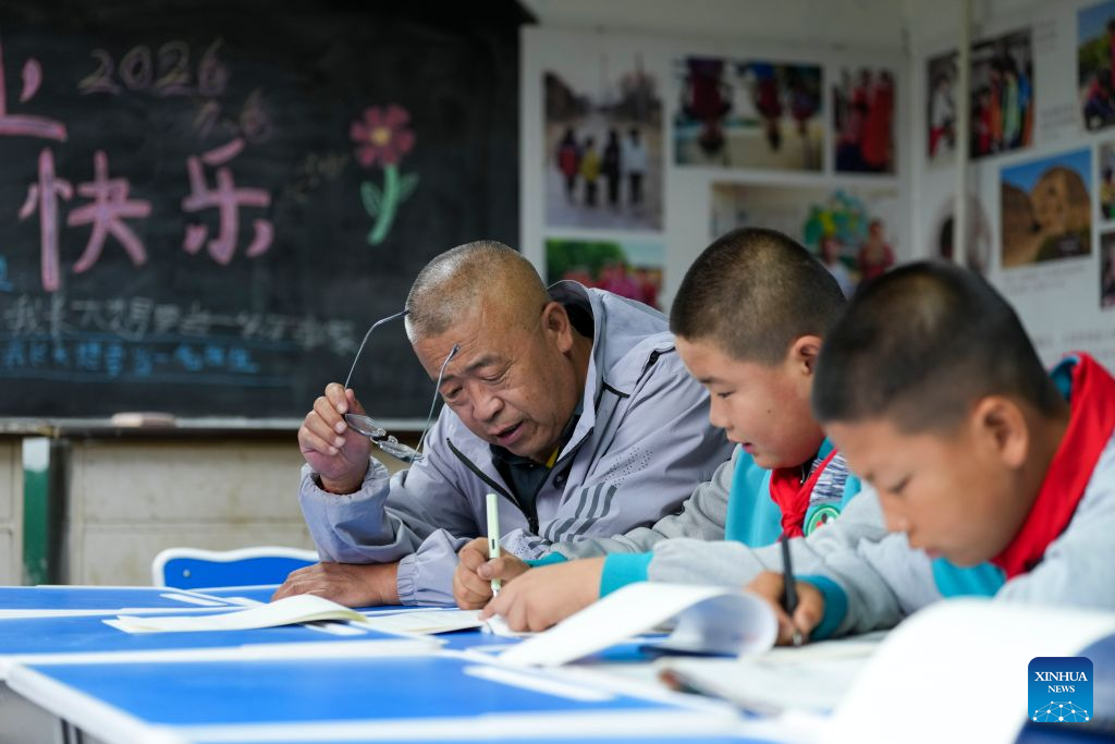 Yao Jian (L) helps students with their homework at Sandun Primary School in Sandun Village, Huayuantun Town of Datong, north China's Shanxi Province, Sept. 7, 2026. (Xinhua/Yang Chenguang)