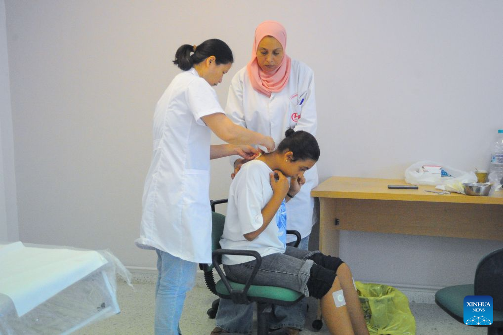 A doctor (L) administers Sanfutie, or Sanfu plaster, a centuries-old traditional Chinese medicine therapy, to a patient in Tunis, Tunisia, Aug. 14, 2026. The 30th Chinese medical team to Tunisia conducted Sanfutie treatments for the Tunisian people on Friday. (Photo by Adel Ezzine/Xinhua)