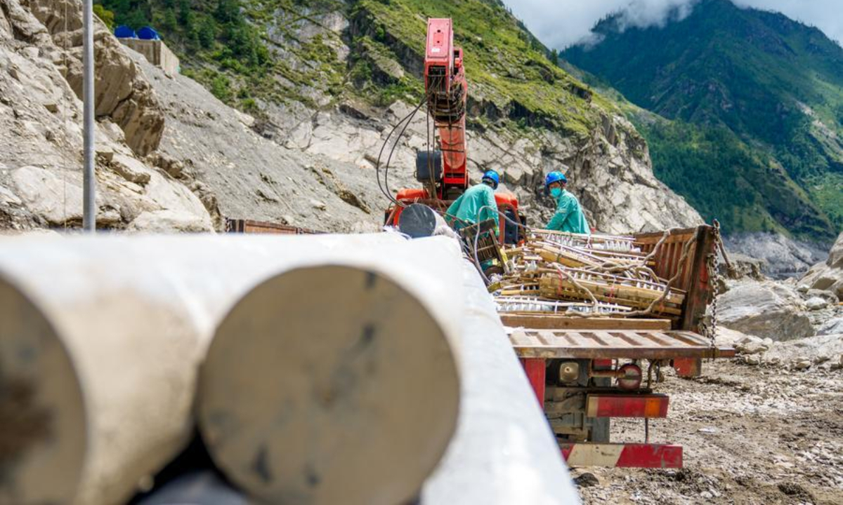Workers transfer utility poles and insulators at the core affected zone of the mudslide-hit Gyirong Port in southwest China's Xizang Autonomous Region, Sept. 3, 2026. (Xinhua/Tenzin Nyida)