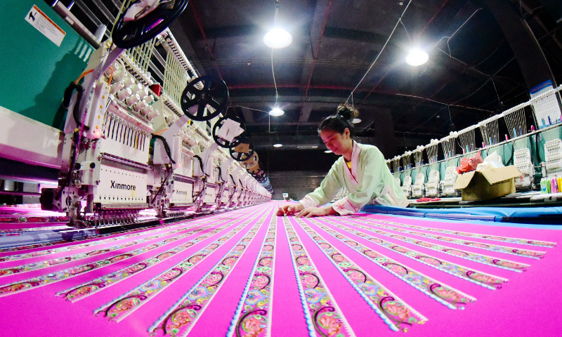 A worker operates an embroidery machine on a production line in Congjiang, Southwest China's Guizhou Province, on August 19, 2026. In recent years, Congjiang has encouraged and supported companies to accelerate technological innovation. It set up workshops for knitting, garments, footwear and toys, and introduced advanced equipment to boost product quality. Enterprises now run at full capacity to fulfill domestic and international orders. Photo: VCG