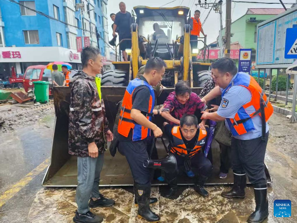 Police officers help to relocate a resident in Chunyang Town of Wangqing County, northeast China's Jilin Province, July 29, 2026. Heavy rainfall has caused flood in Wangqing and trapped residents. Local authorities have carried out emergency rescue and response. (Wangqing Public Security Bureau/Handout via Xinhua)