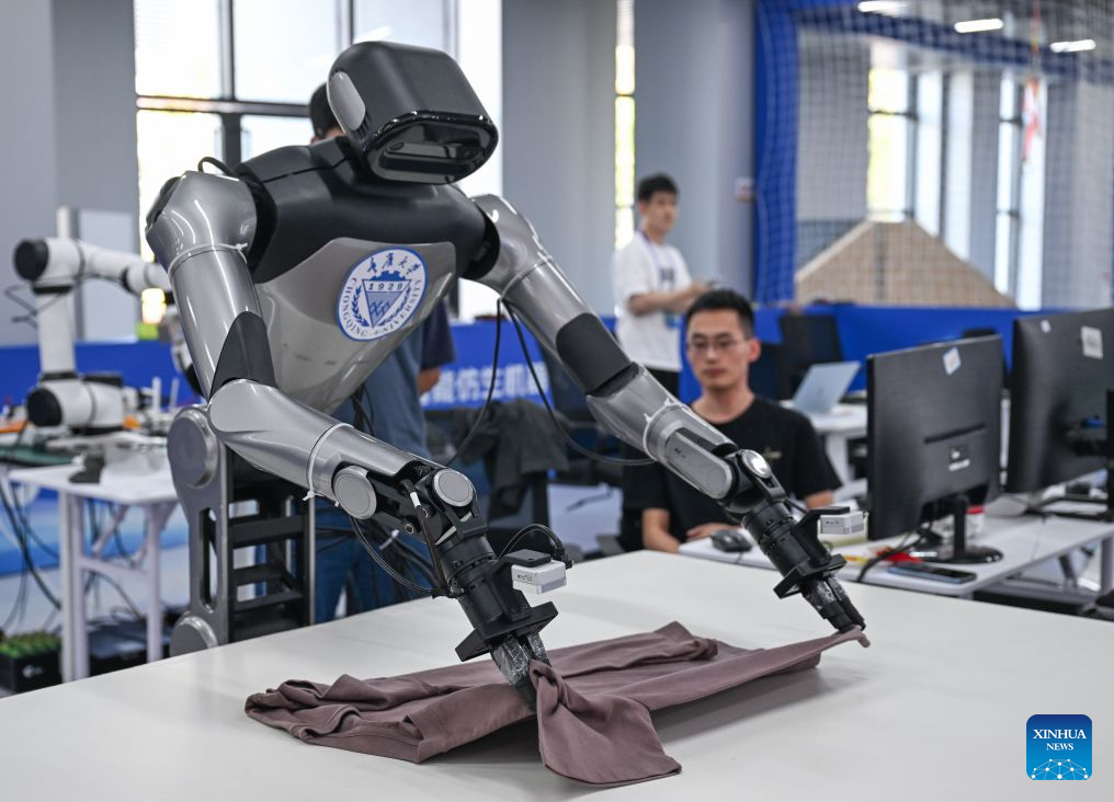 A robot folds the clothes during the final of the 11th Maker in China intelligent bionic robot innovation and entrepreneurship competition for small and medium-sized enterprises in Chongqing, southwest China, Sept. 9, 2026. The final of the event kicked off in Chongqing on Wednesday, with the participation of some 100 teams from all over the country. This competition will last until Sept. 11. (Xinhua/Chen Cheng)