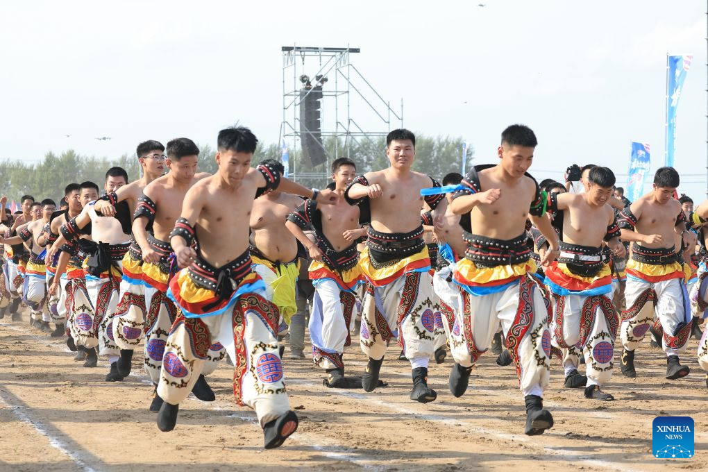 Mongolian wrestlers stride in formation during the opening ceremony of a Nadam fair in the Mongolian Autonomous County of Dorbod, Daqing City, northeast China's Heilongjiang Province, Sept. 6, 2026. The event was held here on Sunday. It featured cultural performances and folk activities, offering tourists and local residents a celebration of grassland culture. (Photo by Xu Shuai/Xinhua)