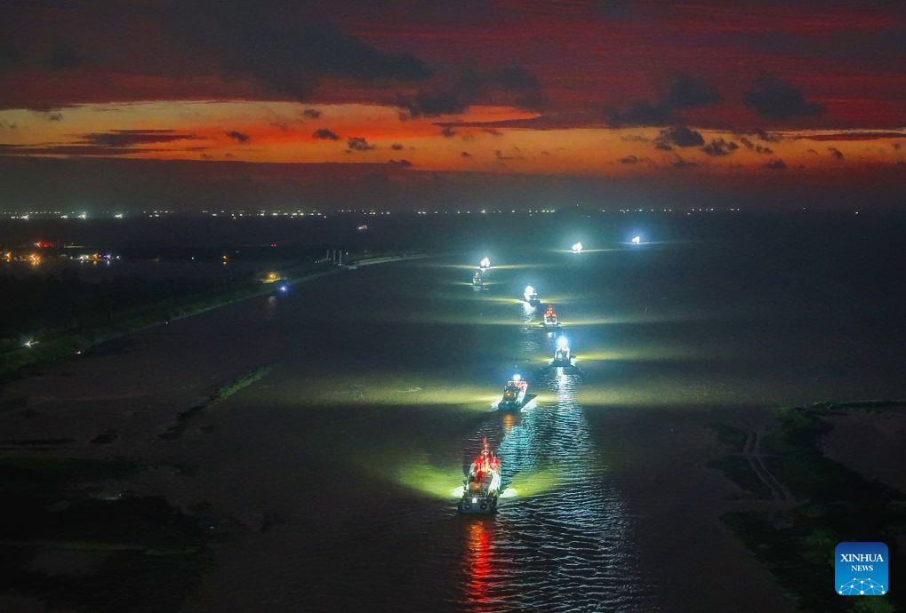 An aerial drone photo taken on Aug. 12, 2026 shows fishing boats departing for the Yellow Sea after a fishing ban was lifted in Lianyungang City, east China's Jiangsu Province. Special licensed fishing vessels set out to the Yellow Sea as the summer fishing moratorium was partially lifted on Aug. 12, which had been postponed for a week due to impacts of Typhoon Dolphin. (Photo by Wang Jianmin/Xinhua)