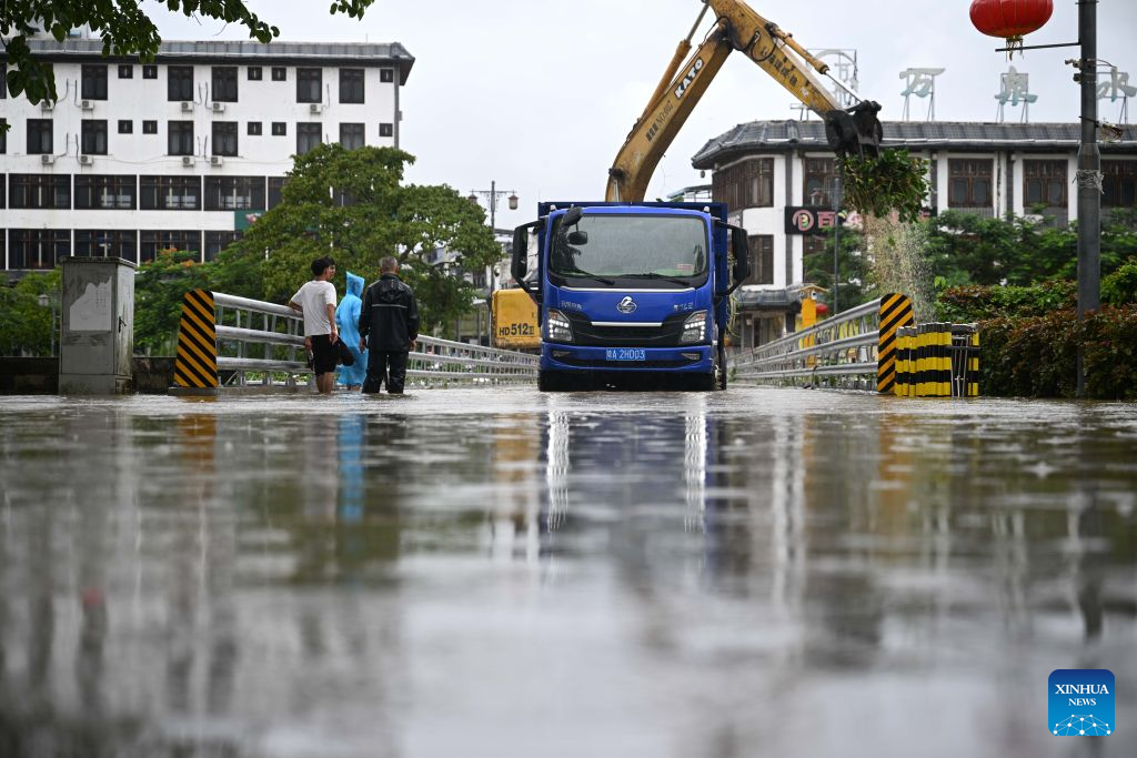 An excavator clears debris blocking the river channel under a bridge in Qionghai, south China's Hainan Province, Sept. 14, 2026. As the intensity and extent of torrential rainfall decreased, Hainan has shifted to full-scale post-disaster recovery operations across the province. (Xinhua/Pu Xiaoxu)