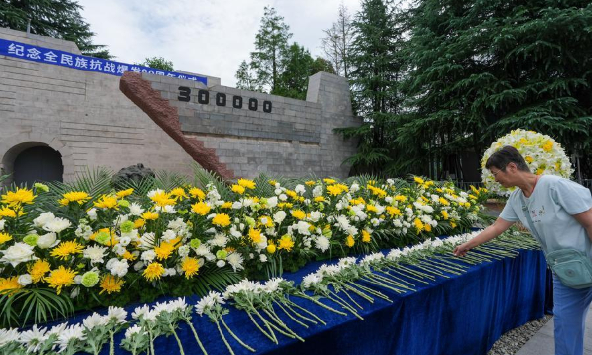 A citizen pays floral tribute during a ceremony marking the 89th anniversary of the beginning of China's whole-nation resistance war against Japanese aggression at the Memorial Hall of the Victims in Nanjing Massacre by Japanese Invaders in Nanjing, east China's Jiangsu Province, July 7, 2026. (Xinhua/Li Bo)