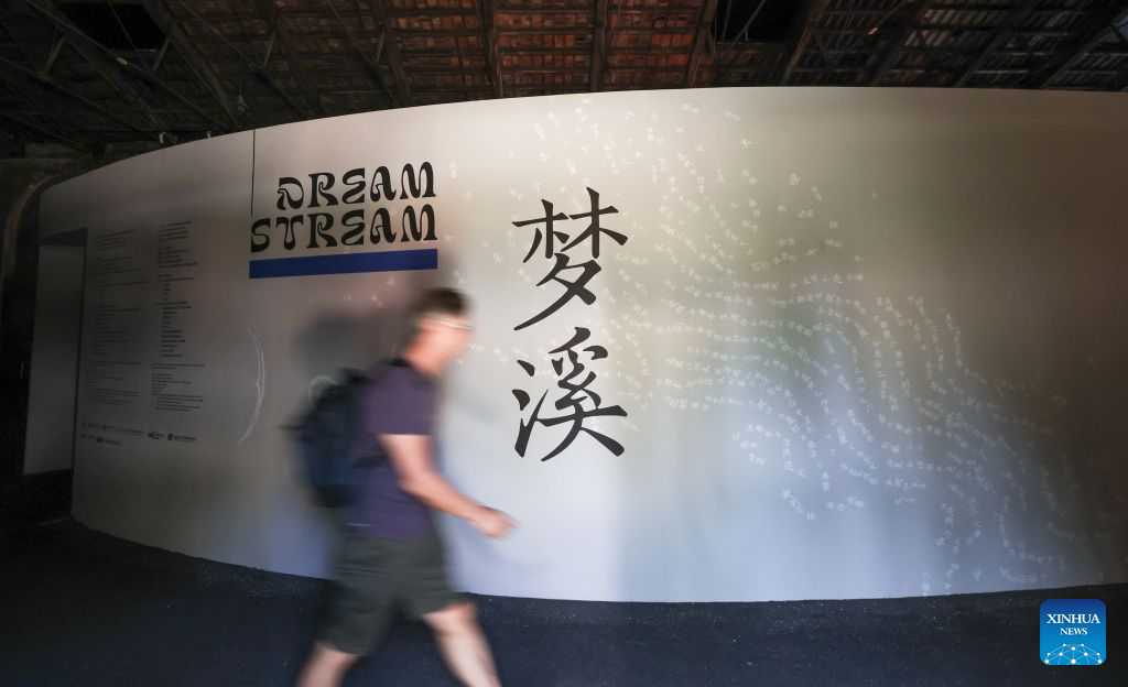 A visitor walks past the main theme poster at the China pavilion themed Dream Stream of the 61st International Art Exhibition of La Biennale di Venezia in Venice, Italy, Sept. 1, 2026. (Xinhua/Wang Kaiyan)