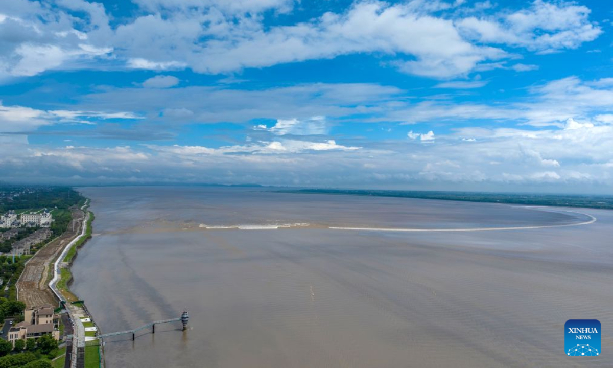 An aerial drone photo taken on Aug. 30, 2026 shows tourists watching the tidal bore of the Qiantang River in Haining City, east China's Zhejiang Province. (Photo by Tang Dehong/Xinhua)