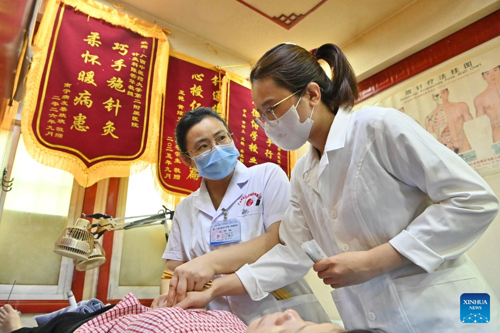 Dr. Chen Manghua explains acupuncture know-how to Thai Thi Hai Yen (R) at the Second Affiliated Hospital of Guangxi University of Chinese Medicine in Nanning, south China's Guangxi Zhuang Autonomous Region, Sept. 17, 2026. (Xinhua/Lu Boan)