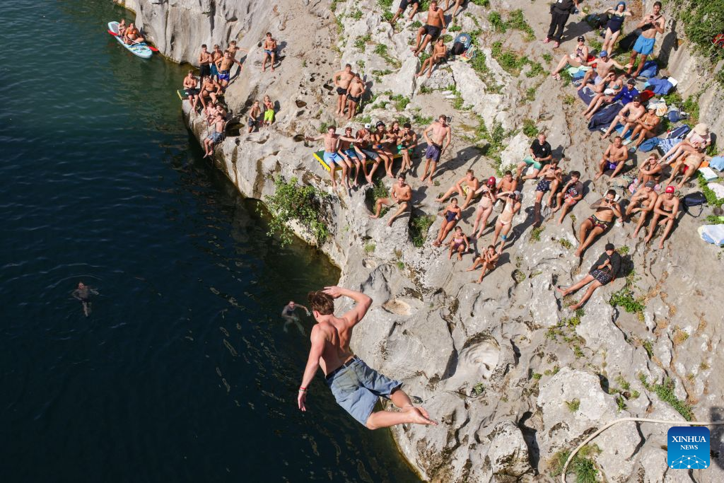 A participant jumps into the River Soca from a 17-meter-high bridge during a traditional jumping event in Kanal ob Soci, Slovenia, on Aug. 16, 2026. (Photo by Zeljko Stevanic/Xinhua)