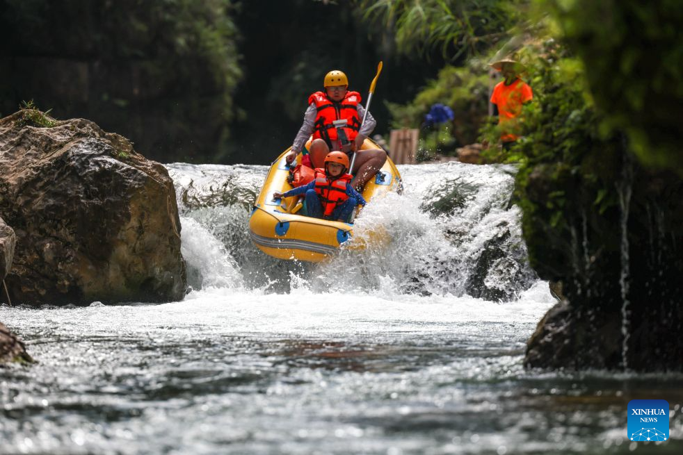 Tourists enjoy rafting at a scenic area in Huangping County, southwest China's Guizhou Province, July 29, 2026. During the summer vacation, Huangping has leveraged its mountain springs and canyon landscapes to develop a rafting tourism brand, attracting visitors for a refreshing getaway while boosting local tourism and incomes. (Xinhua/Yang Wenbin)