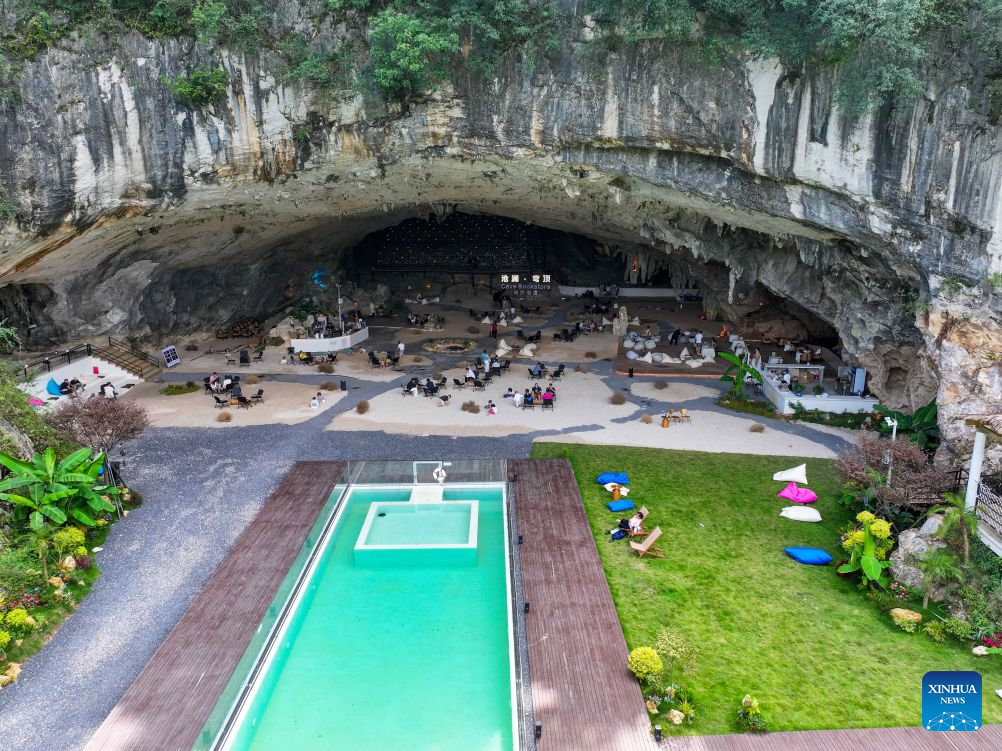 A drone photo taken on Aug. 10, 2026 shows tourists enjoying themselves at a cafe inside a karst cave in Xiuwen County of Guiyang City, southwest China's Guizhou Province. Best known for its karst landscape, Guizhou has made the best of karst caves to develop distinctive sites for cooling retreats. Featuring natural geological wonders, cooling enjoyment and water amusements, this emerging tourist experience has become a hit among locals and visitors alike. (Photo by Yuan Fuhong/Xinhua)