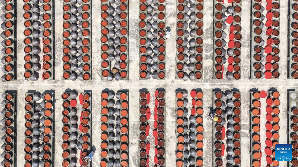 An aerial drone photo taken on Aug. 16, 2026 shows staff members operating at an airing field for chili sauce in Yongfeng Subdistrict of Shuangfeng County, Loudi City of central China's Hunan Province. As one of China's protected geographical indication products, chili sauce made in Yongfeng Subdistrict boasts a history of several centuries. (Photo by Li Jianxin/Xinhua)
